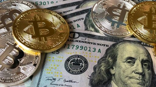 A closeup photo of bitcoin on top of dollar bills