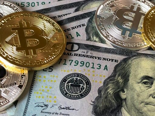 A closeup photo of bitcoin on top of dollar bills