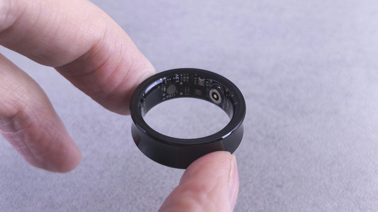 Finger hold a black smart ring