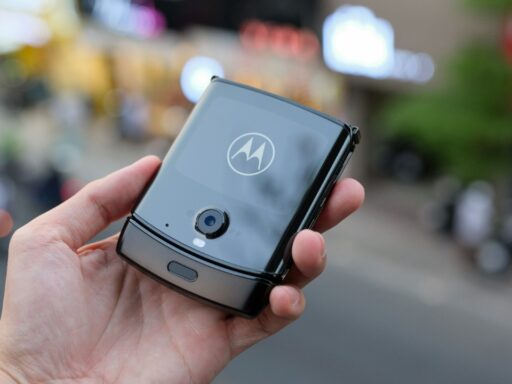 A person holding a Motorola smart phone in his hand