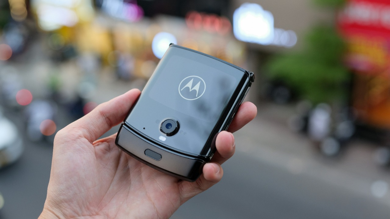 A person holding a Motorola smart phone in his hand